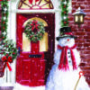 Festive Christmas snowman with red scarf and shovel by red door